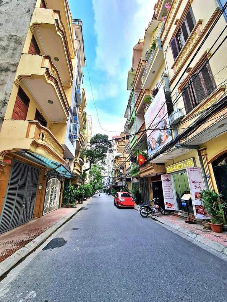 Đường nội khu rộng, hai bên là nhà dân và cửa hàng kinh doanh nhỏ